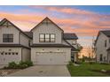 Charming two-story home features a white facade, attached garage, and well-manicured lawn at sunset at 17551 Gruner Way, Westfield, IN 46062