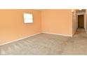 A cozy bedroom with neutral carpet, peach walls, and a window offering natural light at 1802 Sugar Grove Ave, Indianapolis, IN 46202
