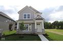 Charming two-story home features board and batten siding, a covered porch, and a well-manicured lawn at 1813 Real St, Indianapolis, IN 46240