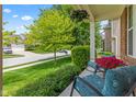 Inviting front porch with comfortable seating and vibrant flowers, set against a lush green lawn at 1821 Midnight Pass, Brownsburg, IN 46112