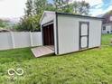 View of a new shed in the backyard with a roll up door and side door at 1834 Chandler Ln, Columbus, IN 47203