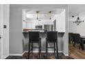 Open kitchen area with white cabinets and bar seating, ideal for casual dining at 2263 Rome Dr, Indianapolis, IN 46228