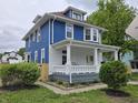 Two-story home featuring a white-columned porch and blue siding at 24 N Randolph St, Indianapolis, IN 46201