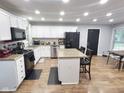 Bright kitchen with white cabinets, granite counters, island and wood floors at 2741 Fairlawn Dr, Columbus, IN 47203