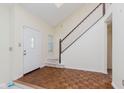 Bright foyer with wood-patterned flooring and a staircase leading to the upper level at 2916 Sunmeadow Way, Indianapolis, IN 46228