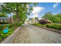 Charming home and garage, featuring a gravel driveway framed by manicured landscaping and mature trees at 311 Northshore Blvd, Anderson, IN 46011