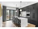 Modern kitchen with island, pendant lights, black cabinets, and stainless appliances at 420 Monon Wy Dr, Carmel, IN 46032