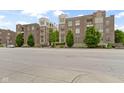 Attractive brick condo building with lush landscaping, a well-maintained lawn, and a tree-lined street at 450 E Ohio St # Apt 305, Indianapolis, IN 46204