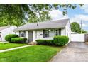 Well-kept home featuring a driveway and a lush green lawn at 4751 Payton Ave, Lawrence, IN 46226