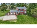 Aerial shot showcases a red brick two-story home with grey roof, brick-lined parking area, and well-manicured front yard at 4817 N 150 W, Anderson, IN 46011