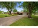 Street view of a brick ranch-style house with a long driveway and an attached garage at 5092 S 50 W, Anderson, IN 46013