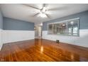 Sunlit living room featuring gleaming hardwood floors, panel moulding, and a large window at 5092 S 50 W, Anderson, IN 46013
