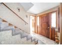Inviting entryway with carpeted stairs, a wood door with a window, and patterned wallpaper at 5939 Olivia Dr, Alexandria, IN 46001