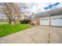 Traditional brick home showcasing a spacious driveway, established landscaping, and an attached two-car garage at 5939 Olivia Dr, Alexandria, IN 46001