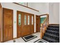 Inviting foyer with tile flooring, a staircase, and a wood door with glass panels, creating an open and welcoming entrance at 5953 Deer Hollow Ct, Pittsboro, IN 46167