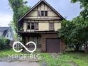 Classic two-story home with Tudor architecture and a detached garage, needing full renovation at 609 E 37Th St, Indianapolis, IN 46205