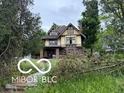 Two story home with Tudor architecture needing full renovation, surrounded by mature trees at 609 E 37Th St, Indianapolis, IN 46205