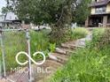 A vintage two-story home needing full renovation, with an overgrown landscape at 609 E 37Th St, Indianapolis, IN 46205