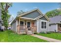 Quaint bungalow with a inviting covered front porch and lush green lawn, perfect for relaxation at 617 N Dearborn St, Indianapolis, IN 46201