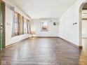 Bright living room with hardwood floors, windows, and an open layout leading to other rooms at 619 Belzer Dr, Anderson, IN 46011