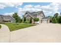 Side view of a two-story home with brick, siding, attached garage, and long driveway at 644 Ridge Gate Dr, Brownsburg, IN 46112
