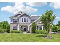 Charming two-story home featuring brick and siding with a well-manicured lawn and blue sky at 644 Ridge Gate Dr, Brownsburg, IN 46112