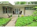 Charming covered front porch with seating and beautiful landscaping at 6550 Sunset Ln, Indianapolis, IN 46260