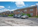 Brick building exterior featuring manicured landscaping and parking lot at 8503 Canterbury W Sq # D, Indianapolis, IN 46260