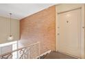 Hallway showcasing a brick wall and stairs leading to the entryway door at 8503 Canterbury W Sq # D, Indianapolis, IN 46260