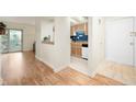 Hallway with wood floors leading to a kitchen and sliding door with access to a balcony at 8503 Canterbury W Sq # D, Indianapolis, IN 46260