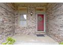 Close-up of the brick entryway, red front door with wreath, and decorative window at 8599 Lansdowne Dr, Fishers, IN 46038