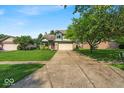 Charming two-story home with a well-manicured lawn, mature trees and an attached two car garage at 8908 Sunningdale Blvd, Indianapolis, IN 46234