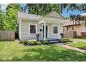 Adorable bungalow featuring a covered front porch, manicured landscaping and inviting walkway at 923 42Nd St, Indianapolis, IN 46205