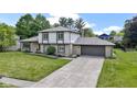 Two-story home with stone facade, gray shingles, an attached garage, and a concrete driveway at 10502 E Lakeshore Dr, Carmel, IN 46033