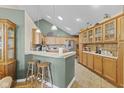 Eat-in kitchen featuring wood cabinets, bar seating, and tile floors for a cozy feel at 1146 Distinctive Way, Greenfield, IN 46140