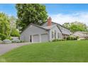 A view of the side of the home with gray siding and brick with an attached garage at 12112 Roxbury Pl, Carmel, IN 46033