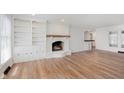 Bright living room with a white painted brick fireplace and built in shelves and cabinets at 12112 Roxbury Pl, Carmel, IN 46033