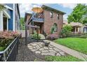 Beautifully landscaped front yard with a stone walkway, swing, and lush greenery enhances the home's curb appeal at 1436 Central Ave, Indianapolis, IN 46202