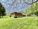 Beautiful home with a large lawn surrounded by mature trees, providing a serene and private setting at 1579 Crest Dr, Shelbyville, IN 46176