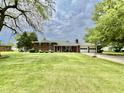 Lovely brick home with lush front lawn, covered porch with seating and a two-car garage at 1579 Crest Dr, Shelbyville, IN 46176