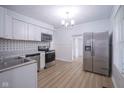 Bright kitchen features white cabinets, stainless steel appliances, and updated flooring at 2012 George St, Anderson, IN 46016