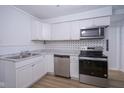 Modern kitchen showcasing stainless appliances, white cabinetry, and tiled backsplash at 2012 George St, Anderson, IN 46016