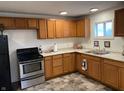 Functional kitchen with stainless steel appliances, wood cabinets, a double sink, and a window at 2608 S Rybolt Ave, Indianapolis, IN 46241