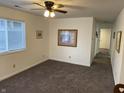 Inviting living room featuring neutral walls, plush carpet, a ceiling fan, and a bright window for natural light at 2608 S Rybolt Ave, Indianapolis, IN 46241
