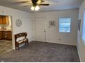Cozy living room with a ceiling fan, neutral walls, plush carpet, and entry to kitchen at 2608 S Rybolt Ave, Indianapolis, IN 46241