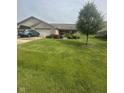 Attractive brick home with lush front yard, a tree, and a car parked in the driveway at 2916 Wind Chime Cir, Greenwood, IN 46143