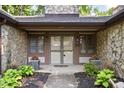 Inviting front entrance with stone accents, decorative plants and address number above the door at 2947 Talping Row, Indianapolis, IN 46268