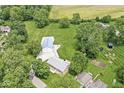 Expansive aerial view of the property, showcasing the home, outbuilding, and surrounding greenery and farmland at 312 W Clark Ln, Fairland, IN 46126