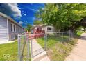 Cozy home with a fenced yard, a red deck, and a welcoming curb appeal at 3220 Newton Ave, Indianapolis, IN 46201