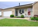 Close-up view of the front of a charming home with tidy landscaping and an attached garage at 3645 Richland Dr, Columbus, IN 47203